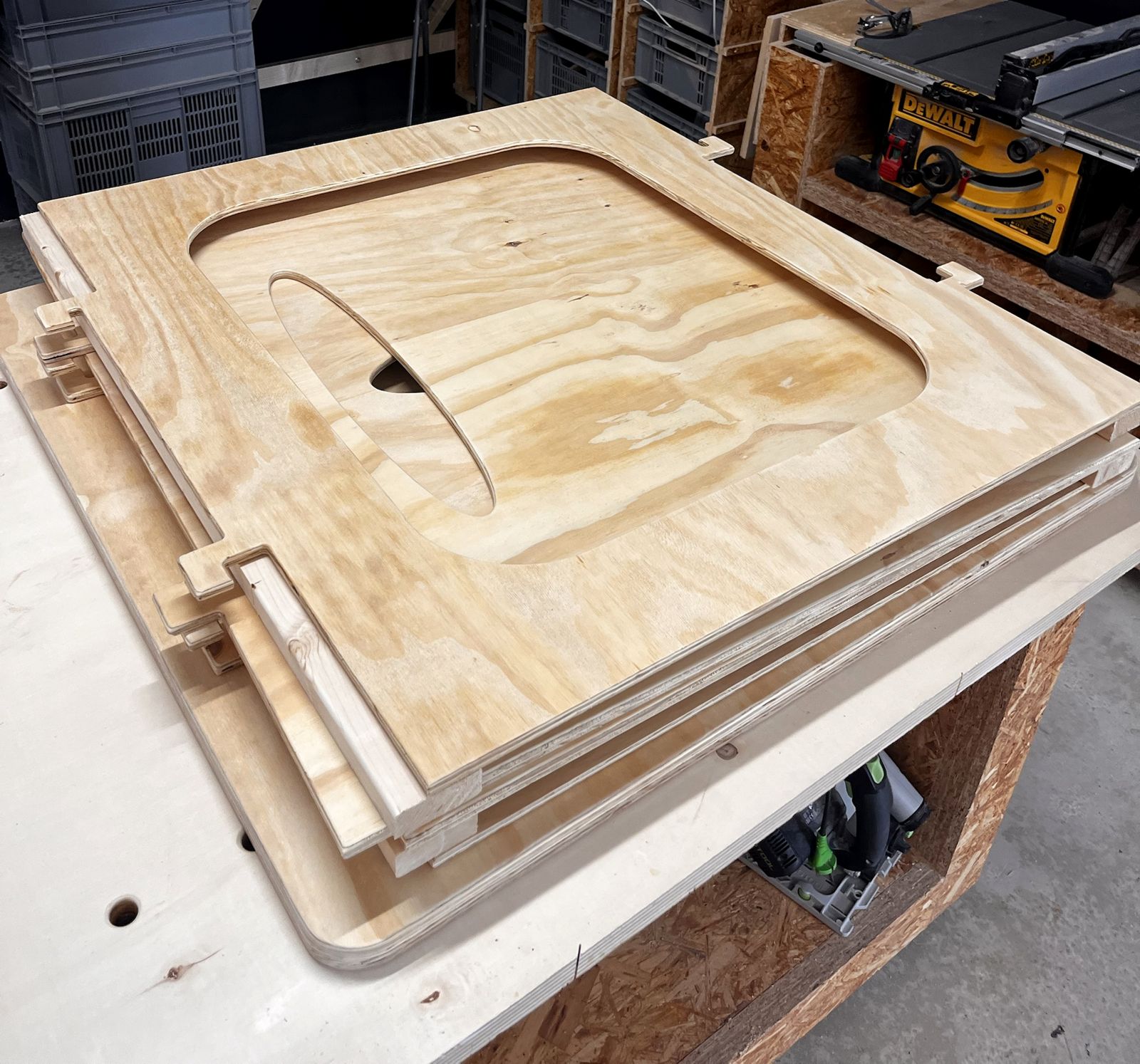 The playhouse panels stacked flat on a workbench