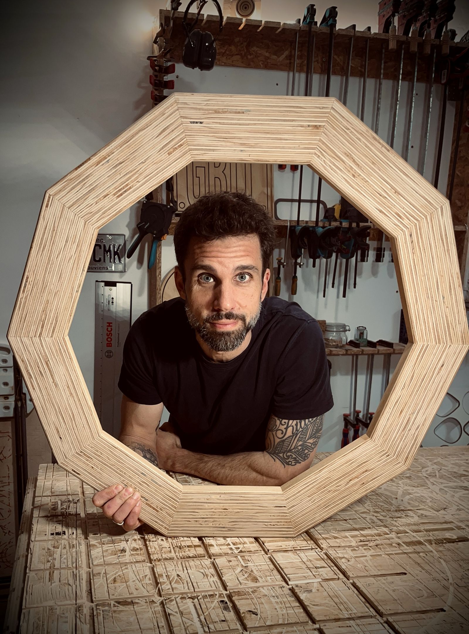 Esteban Ochando in his workshop, looking through a twelve-sided plywood frame